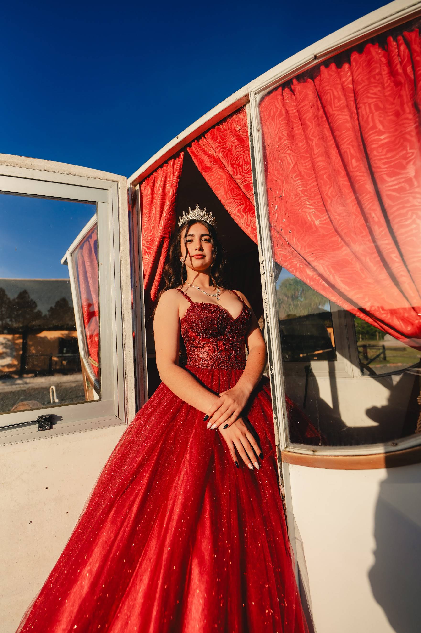 Vestido de 15 rojo con tirantes finos, corset bordado y falda de tul con brillos